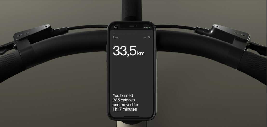 Smartphone mounted on electric bike handlebars displaying trip distance and calories burned.